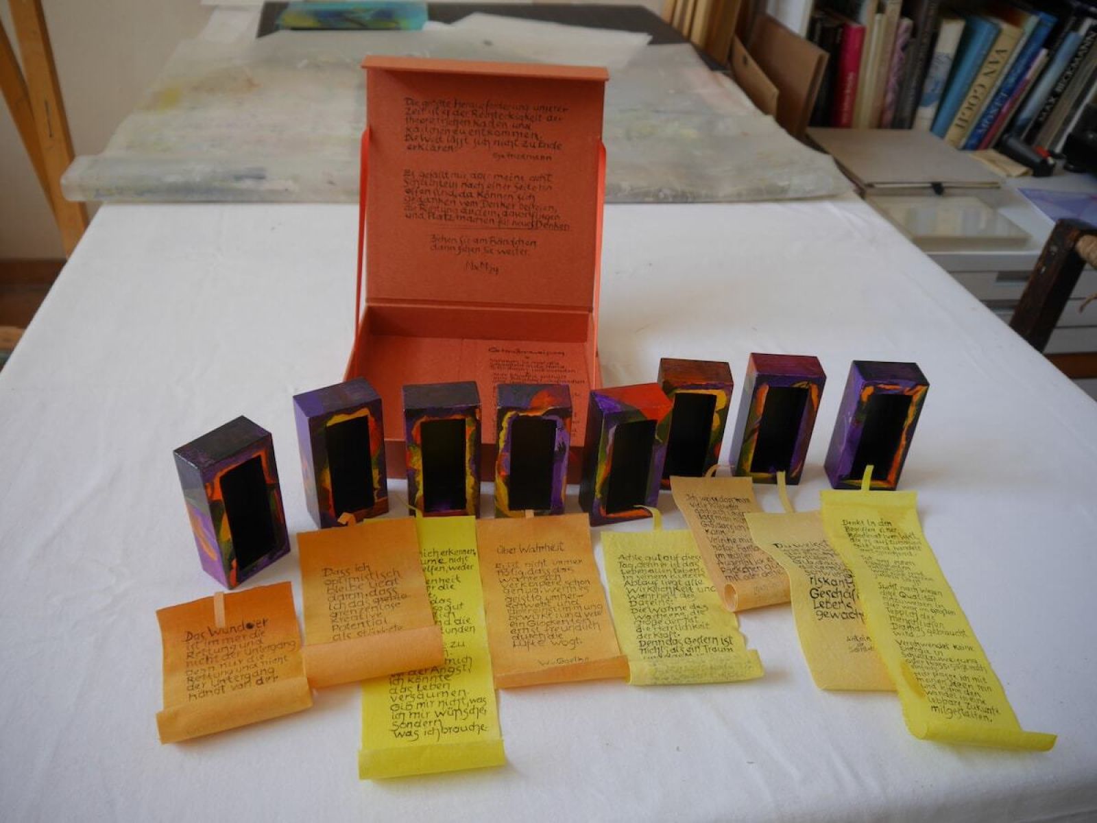 Schachtel mit 8 Kasterln und ausgerollten Texten